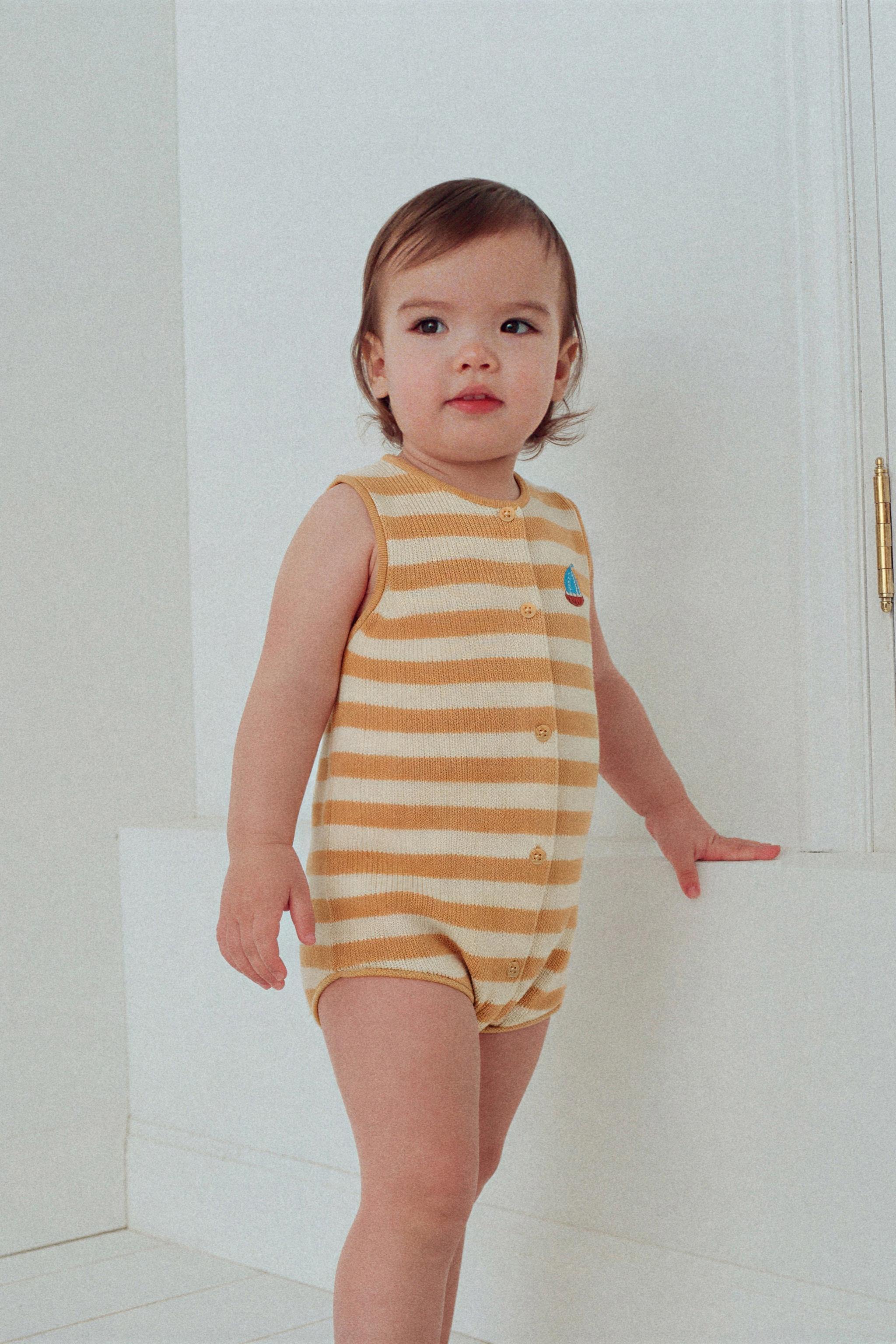 STRIPED KNIT ROMPER WITH EMBROIDERED BOAT